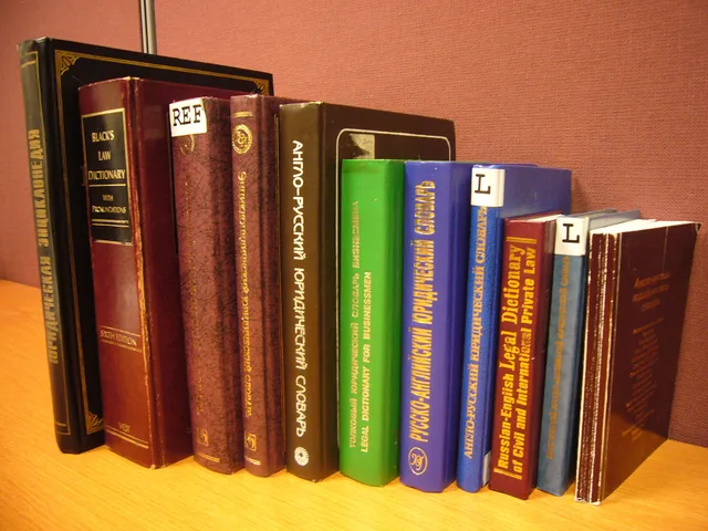 A stack of legal dictionaries on a desk. When to put PPC agencies commercial contracts under legal review